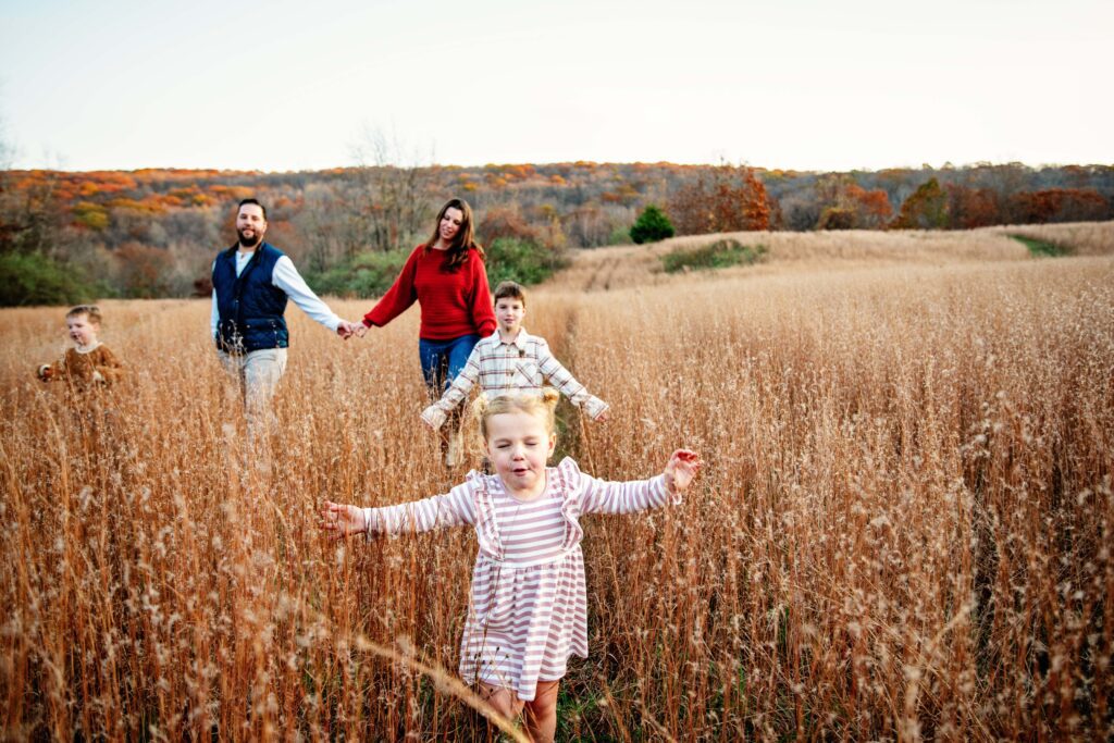Little girl running through the field during a family photo shoot in Jefferson NJ
