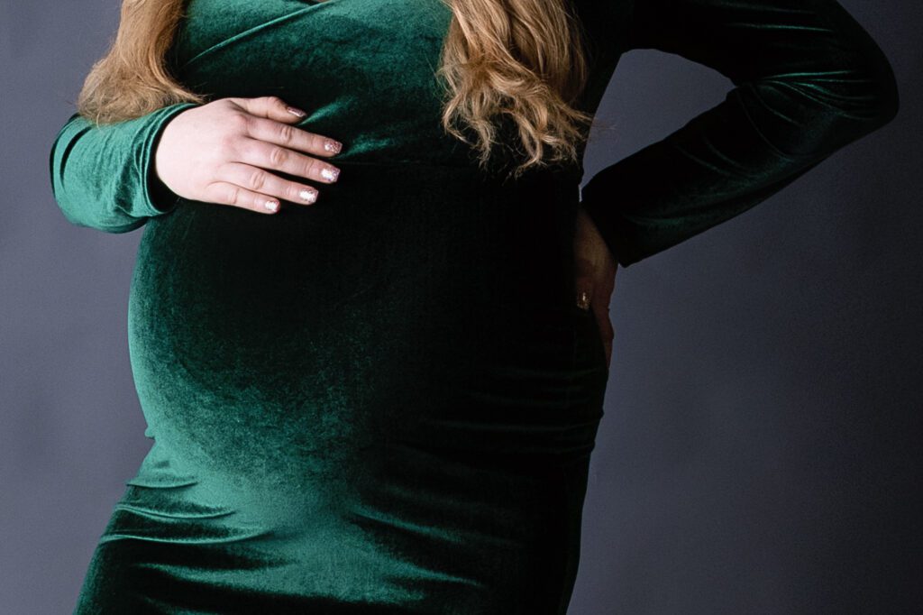 Mom to be wearing a green dress during her maternity photo shoot in Jefferson NJ 