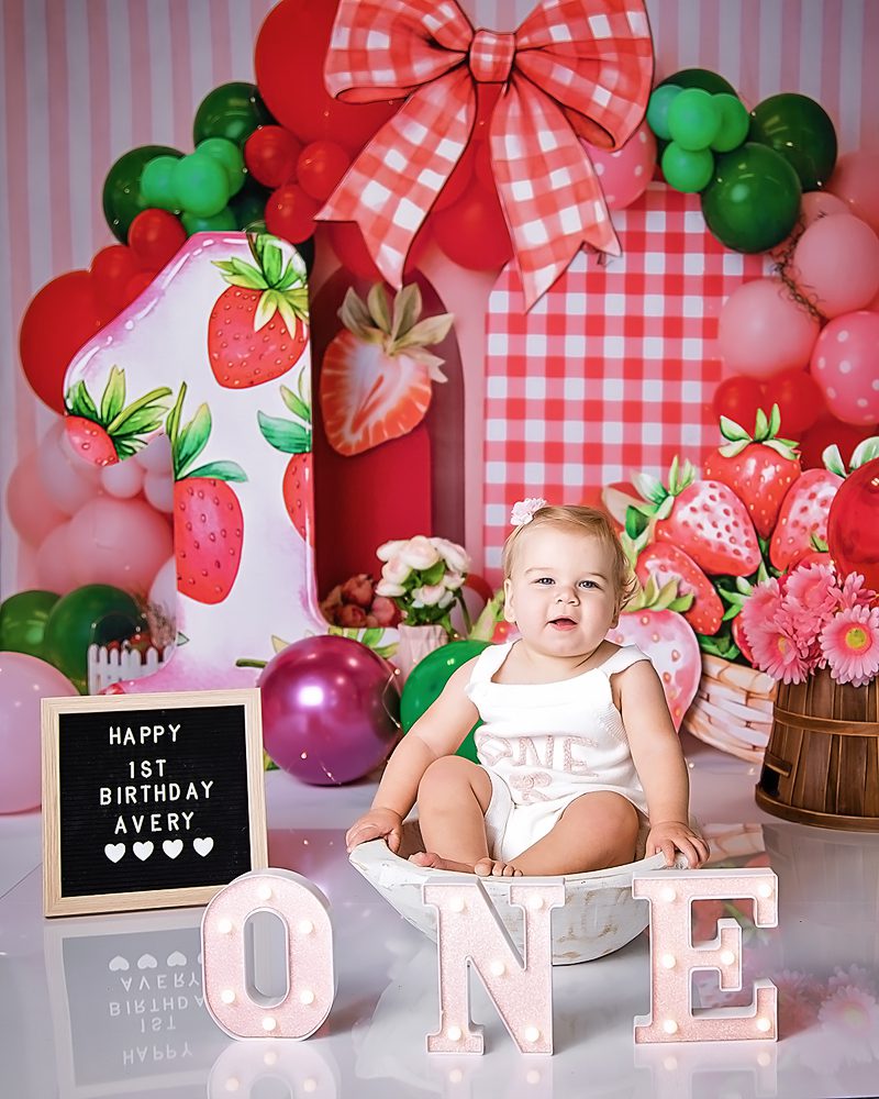 Little girl sitting in the white bowl for her portrait session before her cake smash photo shoot. 